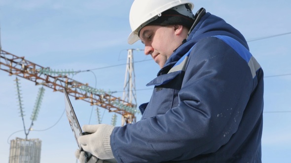 Engineer With Portable Computer at Electric Power Station