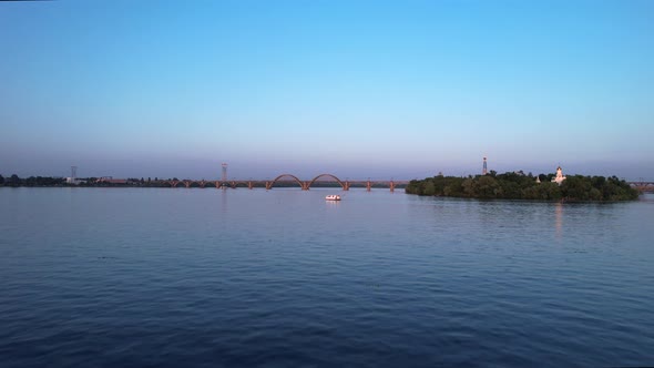 Arch bridge and Monastyrsky Island in the rays of the sunset, Dnipro, Ukraine.