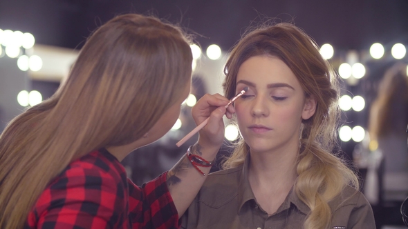The Makeup Artist Correcting the Shape of Eyebrow