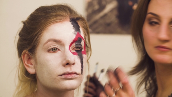 Makeup Artist Drawing Red Lines on the Face
