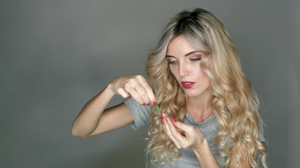A Transparent Contact Lens in the Hands of a Beautiful Blonde Who Is Preparing To Insert It
