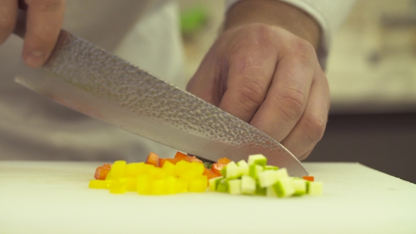 Hands of Chef Cutting Up Vegetables with a Knife