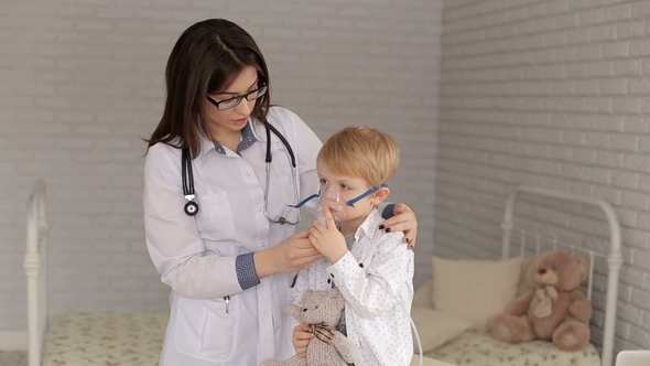 A Small Child with an Inhalation Mask in Hospital. alt