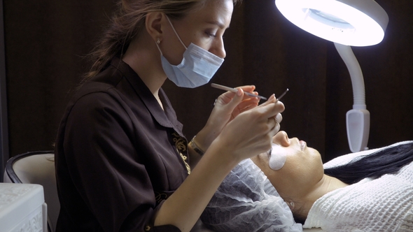 Beautician Makes Procedure of Eyelash Extension in Beauty Salon alt