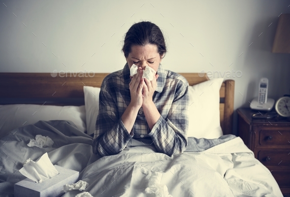 A woman suffering from flu in bed - Stock Photo - Images