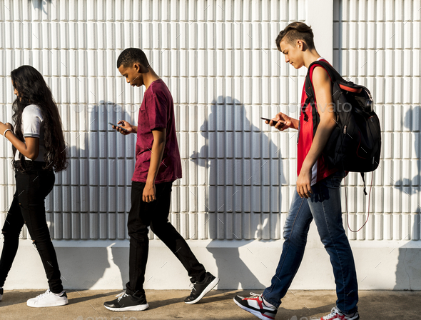 Group of young teenager friends walking home after school using smartphones addiction concept - Stock Photo - Images