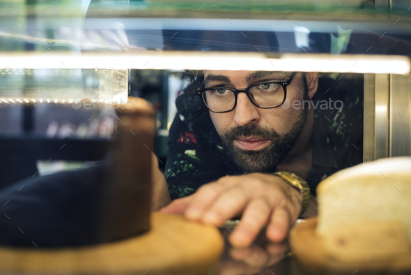 Man getting cake out of the display fridge