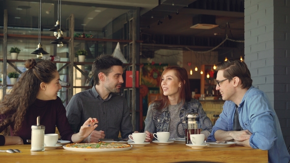 Cheerful Attractive Young Lady Telling Funny Story to Her Friends at Lunch in Cafe alt