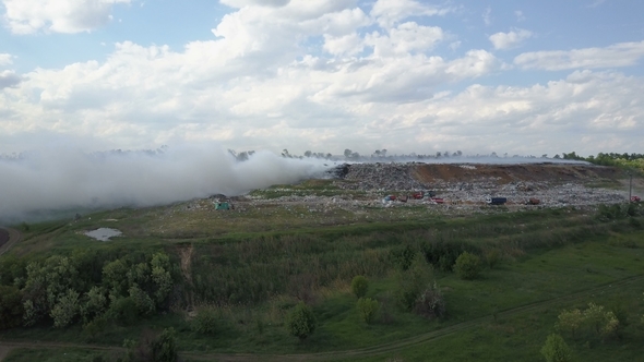 Garbage Dump Pollutes the Environment. Strong Wind Rises Toxic Smoke of Burning Garbage Into the Air alt