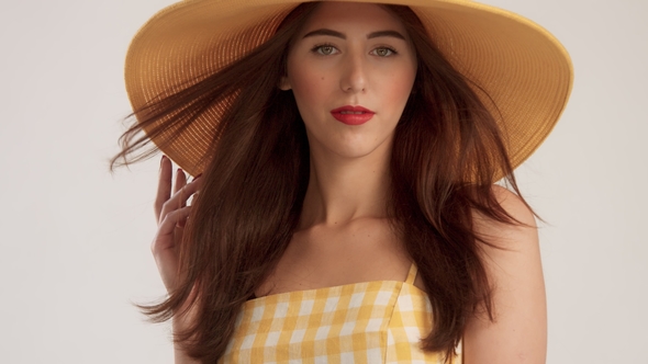 Portrait of Woman with Large Straight Hair Wears Big Summer Yelow Hat