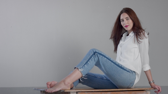 Woman in Industrial Studio Wears Jeans and White Shirt