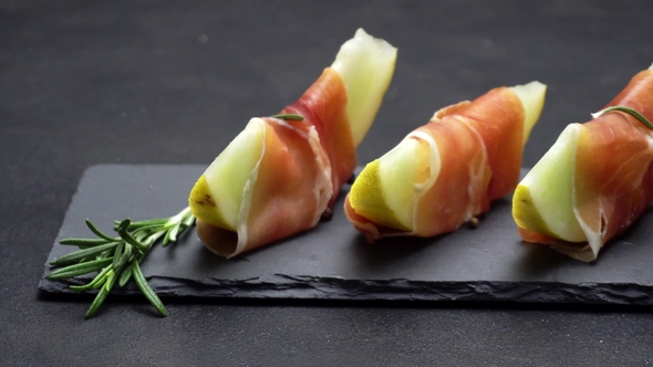 Sliced Prosciutto and Melon on a Stone Board alt