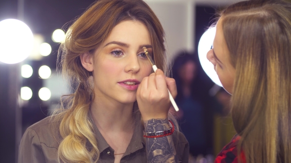 The Makeup Artist Correcting the Shape of Eyebrow