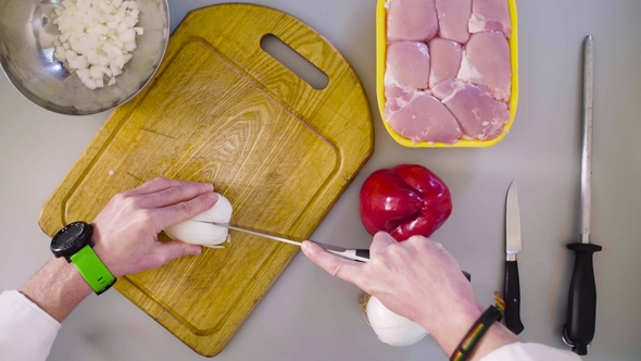 Chef Cooking a Chicken Dish. Cutting Onion