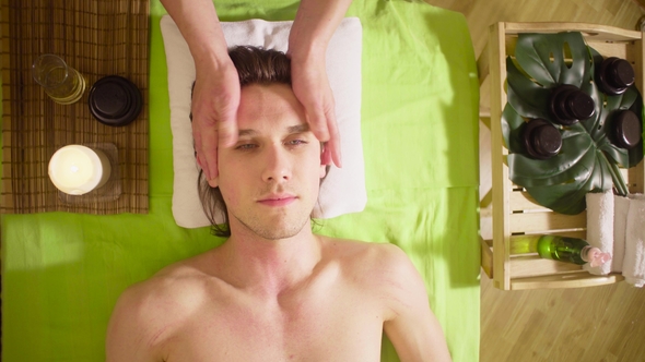 Hands of Therapist Doing Massage of Male Face