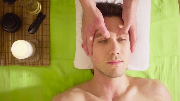 Hands of Therapist Doing Massage of Male Face