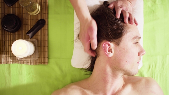 Hands of Therapist Doing Massage of Male Head