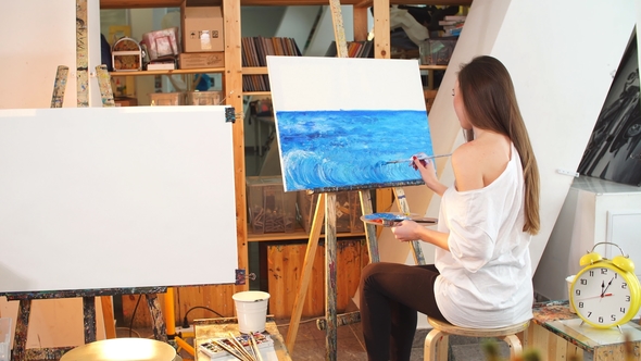 A Young Female Artist Painting Picture on Canvas with Blue Oil Paints ...