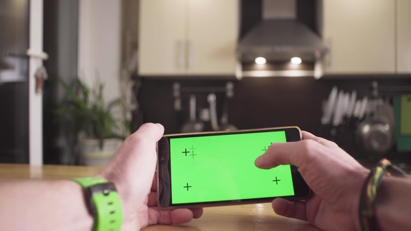 Male Hand Scrolling a Smartphone with Green Screen