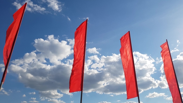 Red Flags Swaying in Wind Against the Blue Sky
