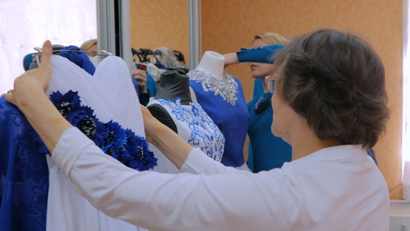 Two Fashion Designers Working with New Model Tailoring Dress on Mannequin