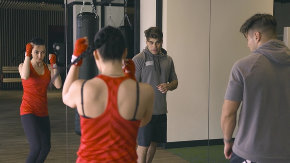 Woman Training with Coach in Front of Mirror