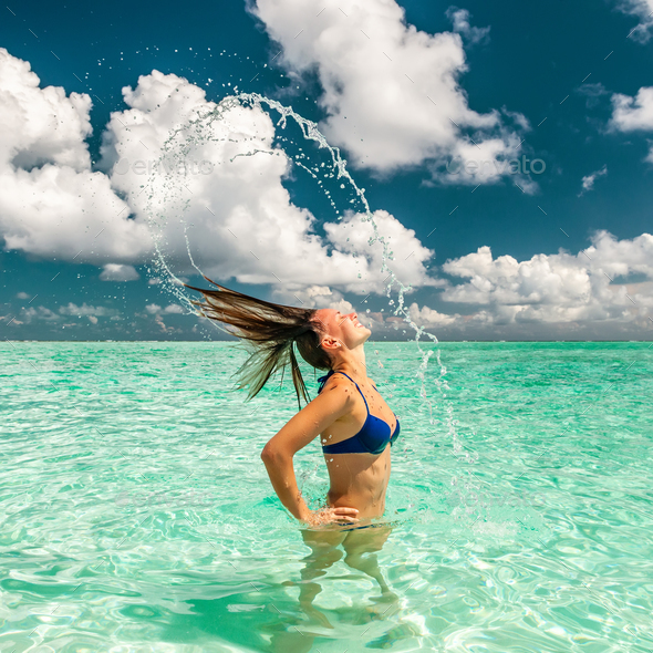 Woman splashing water with hair in the ocean Stock Photo by haveseen