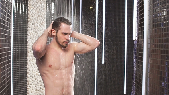 young-sportsman-is-taking-a-shower-after-jogging-touch-hair-stock