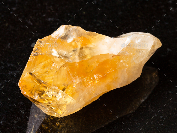 raw crystal of Citrine gemstone on black - Stock Photo - Images