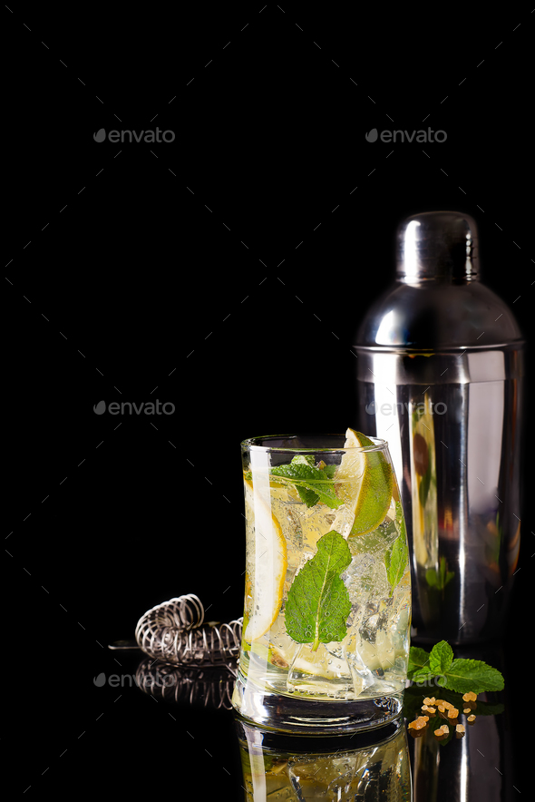 Glass of a cold cocktail drink with tonic served with brown sugar and shaker - Stock Photo - Images