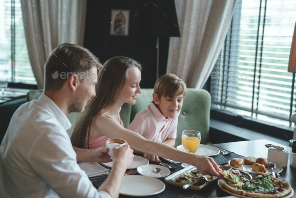 Dining family with child Stock Photo by AboutImages | PhotoDune