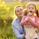 A Sweet Little Girl with Two Tails on Her Head, Along with Her Mother, Is Deliberately Blowing a - VideoHive Item for Sale