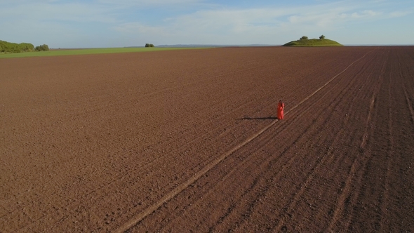 Beautiful Girl Wearing Long Red Dress Walk on Plowed Field alt