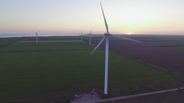 Wind Turbine Power Generators Silhouettes at Sea Coastline at Sunset. Alternative Renewable Energy alt