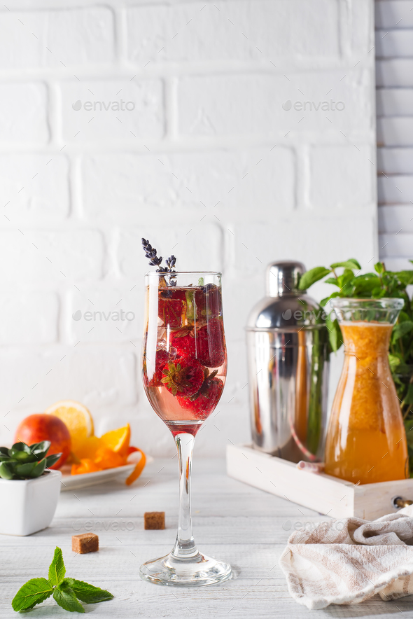 Refreshing cocktail with champagne and cranberry with ice, ginger and lavender on wooden background - Stock Photo - Images
