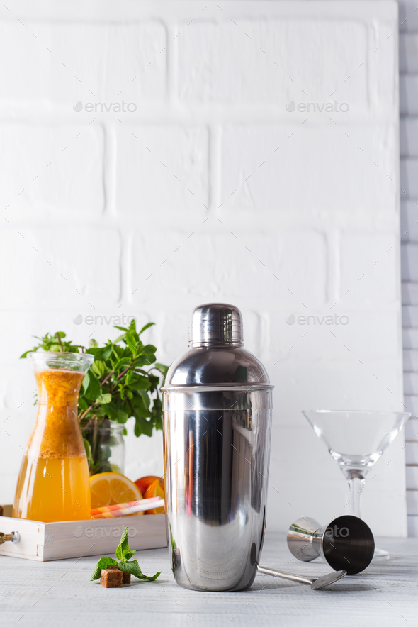 Cocktail shaker, swizzle, tongs and spoon with ice in a bucket for preparing a summer cocktail - Stock Photo - Images