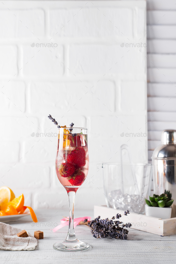 Refreshing cocktail with champagne and cranberry with ice, ginger and lavender on wooden background - Stock Photo - Images