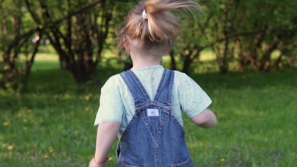 Little Girl Runs Along Grass, Back View