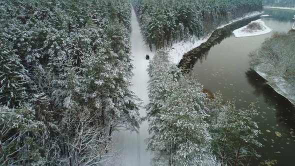 Aerial View of Car Moving in Winter Forest