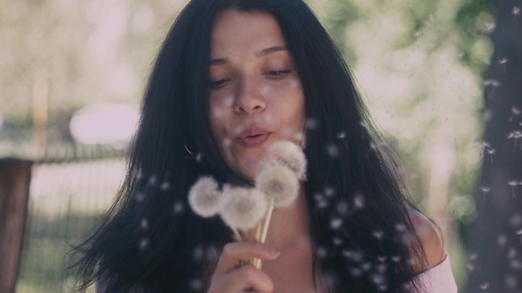 Woman Blowing on a Dandelion in alt