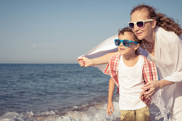 Mother and son standing on the beach at the day time. - Stock Photo - Images