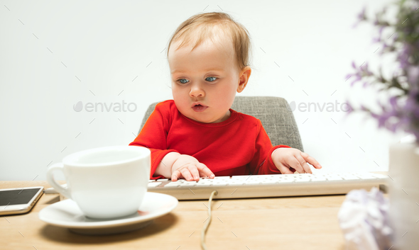 Happy child baby girl toddler sitting with keyboard of computer isolated on a white background - Stock Photo - Images