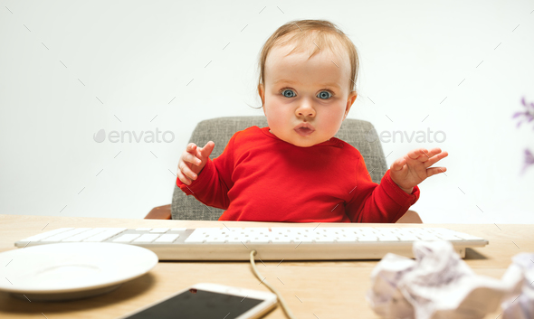 Happy child baby girl toddler sitting with keyboard of computer isolated on a white background - Stock Photo - Images