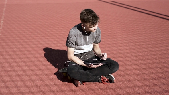 Teen Boy with Headphones and Tablet