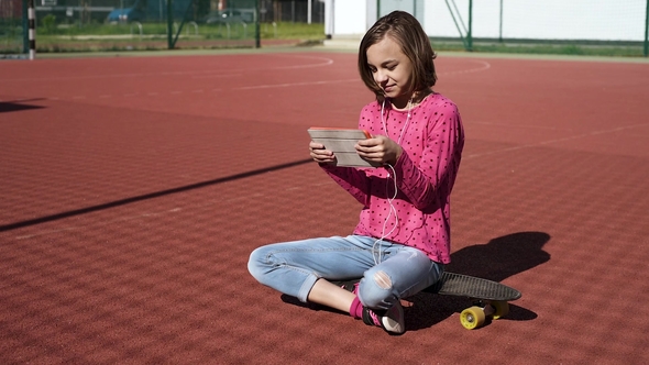 Teen Girl with Headphones and Tablet