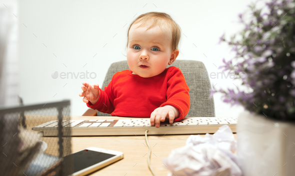 Happy child baby girl toddler sitting with keyboard of computer isolated on a white background - Stock Photo - Images