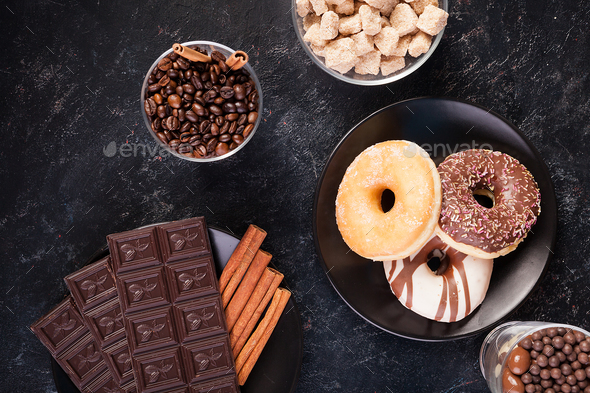 Top view of chocolate tablets, donuts, brown sugar with peanuts in chocolate and coffee beans - Stock Photo - Images
