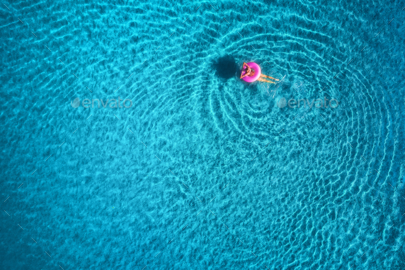 Aerial view of young woman swimming in the sea with transparent water - Stock Photo - Images