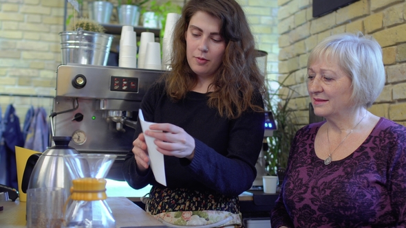Barista Tells Mature Woman about Coffee Filters and How to Use Them alt