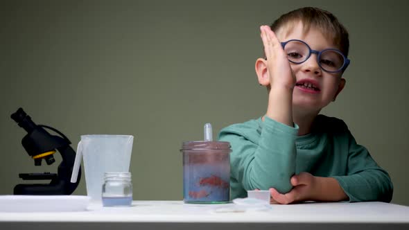 Alternative School. Boy in Glasses Doing Experiment. Young Scientist Mixing Up Licquid for